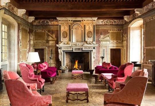 Stone great hall with an oversized fireplace, beamed ceiling and long refectory table