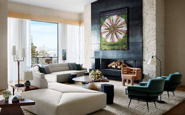 Hotel sitting room with tall windows, grouped seating and hung work on the walls