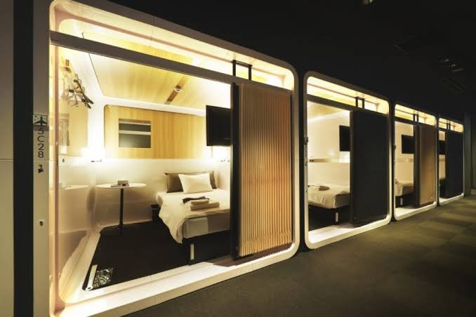 Interior corridor lined with compact cabin openings under even ceiling lighting