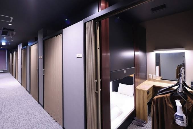 Stacked compact sleeping cabins in two tiers with panels at each opening