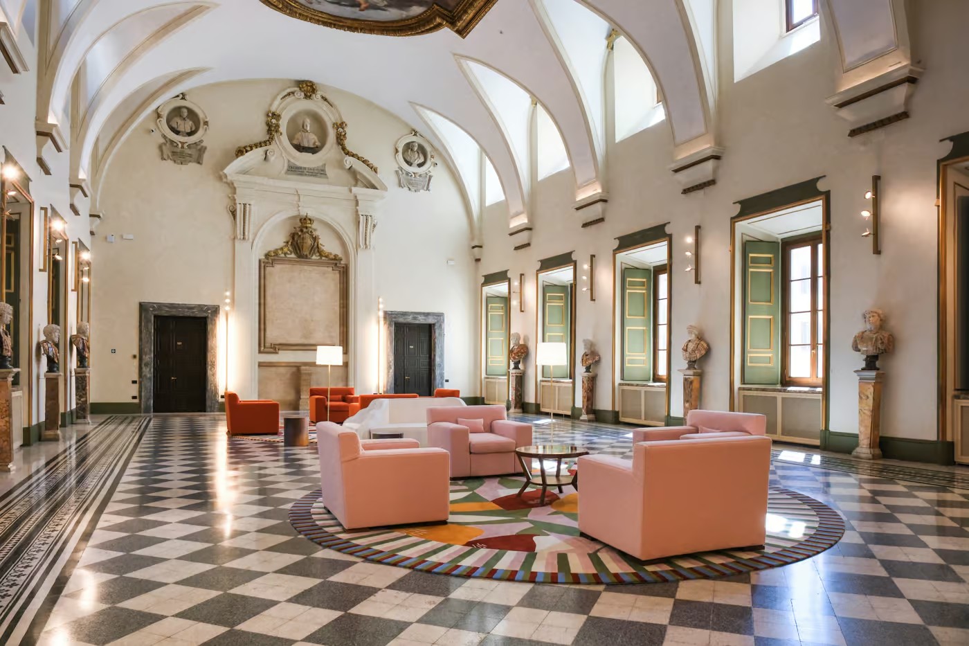 Vaulted hall with painted walls and ceiling above sparse low furniture